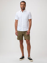 Man wearing a white short-sleeve shirt and green shorts | FCT makes better basics