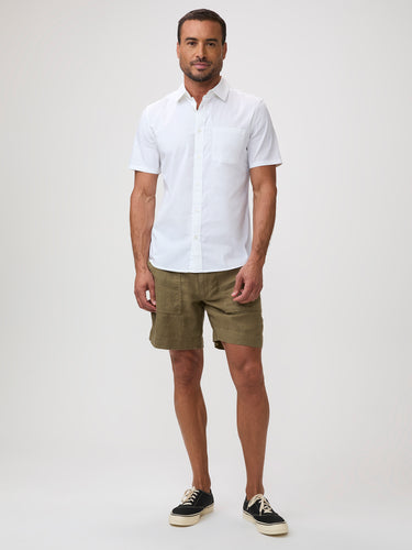 Man wearing a white short-sleeve shirt and green shorts | FCT makes better basics