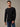 A man wearing a black long-sleeve flannel shirt and blue jeans. The thermal that keeps up with the whole weekend.