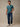 Man in teal v-neck t-shirt standing, casual style. Teal blue v-neck t-shirts for everyday wear.