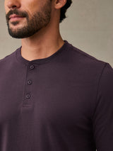 Close-up of button placket detail on mulberry colored henley shirt